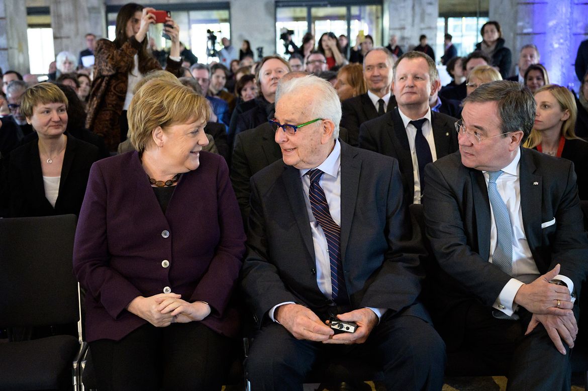 Chancellor Angela Merkel sits beside Holocaust survivor Naftali Fürst at the opening of the "Survivors" exhibition.