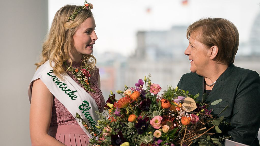 Die Deutsche Blumenfee überreicht einen Blumenstrauß an Bundeskanzlerin Angela Merkel.