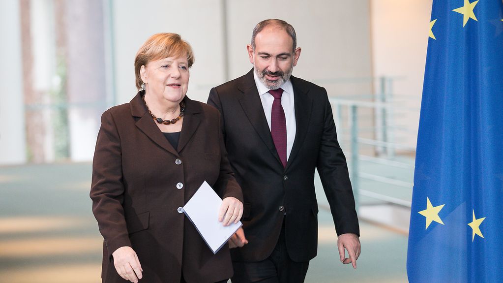 Chancellor Angela Merkel and Prime Minister Nikol Pashinyan beside an EU flag
