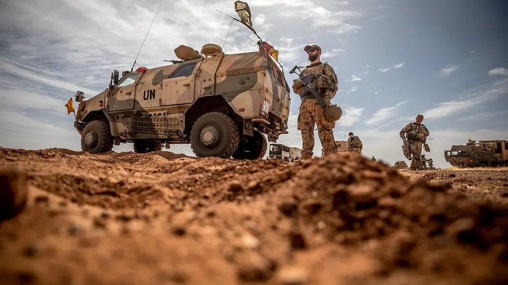 Ein Bundeswehr-Soldat steht neben einem Einsatzfahrzeug