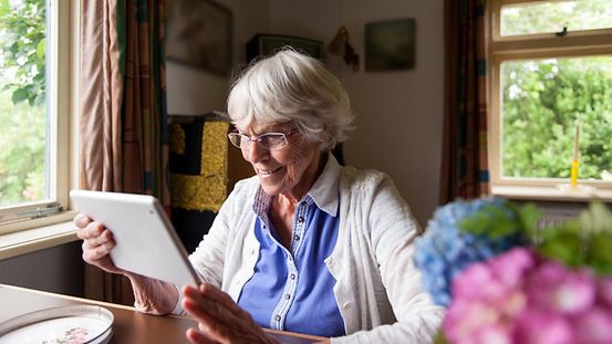 Eine ältere Dame mit einem Tablet