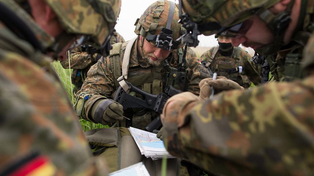 Soldatebn der Bundeswehr beugen sich bei ener Übung über eine Landkarte.