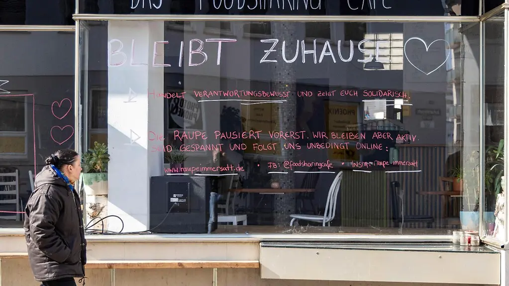 Beschriftete Glasfront eines geschlossenen Cafés.