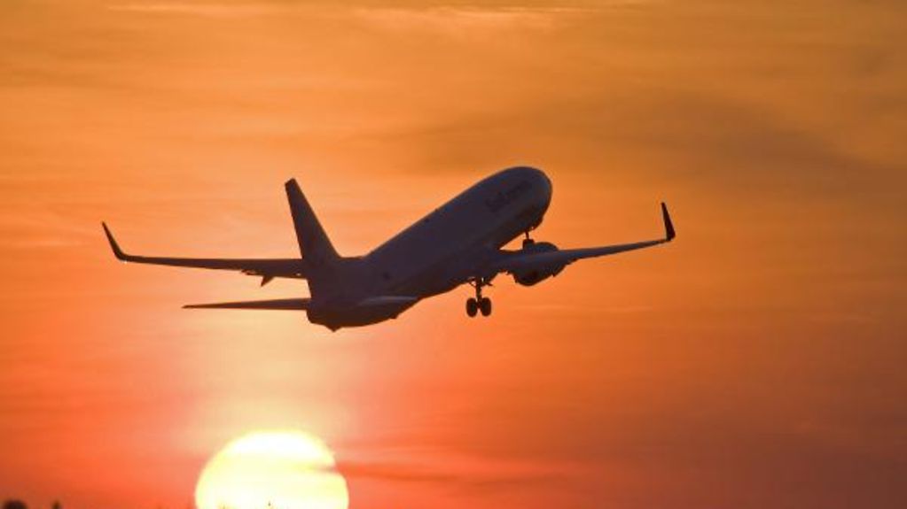 Ein Passagierflugzeug startet bei Sonnenuntergang.