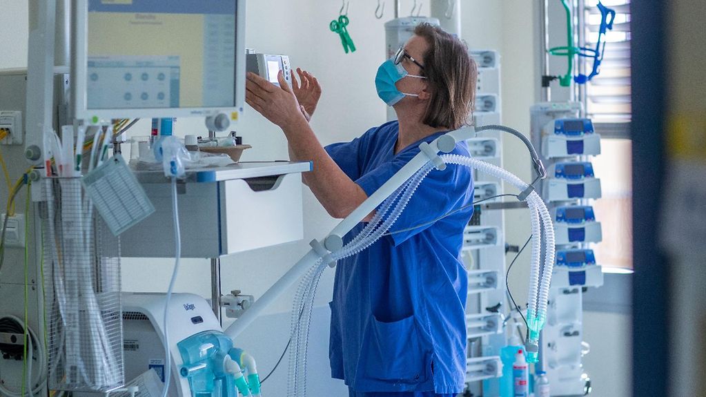 Eine Krankenschwester prüft ein Beatmungsgerät auf einer Intenmsivstation