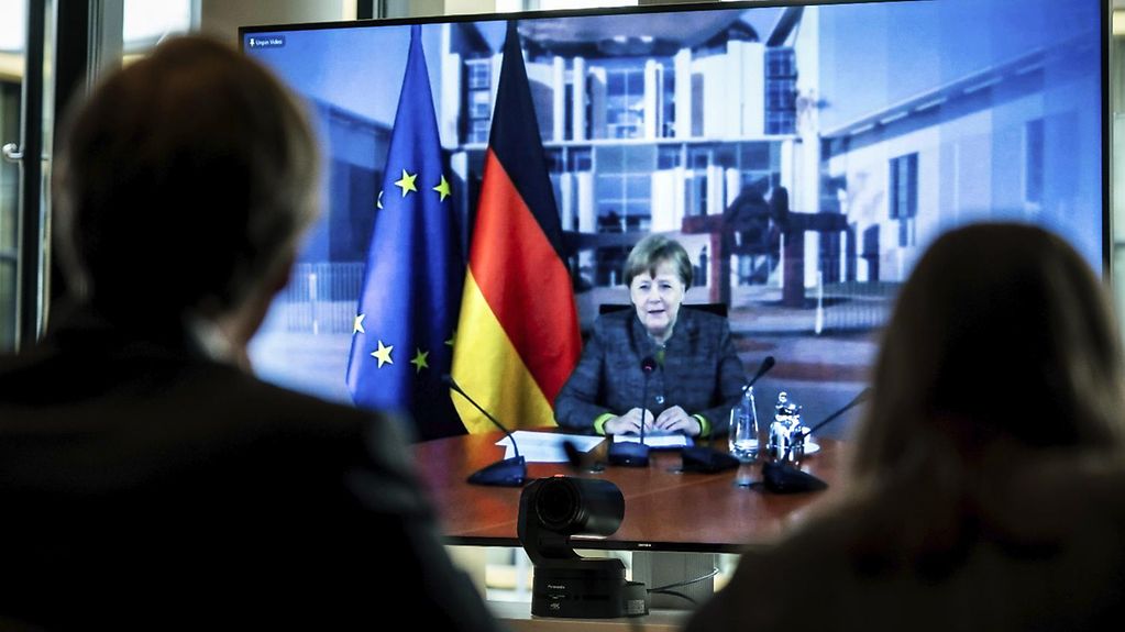 Bundeskanzlerin Merkel ist auf einem Bildschirm zu sehen, während sie ihre Rede auf dem Petersberger Klimadialog hält. 