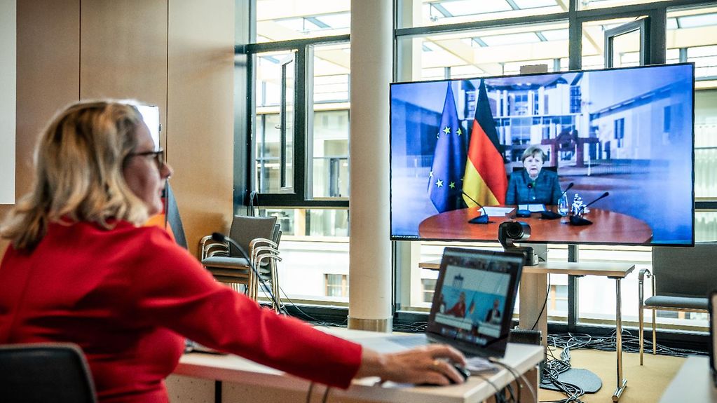 Kanzlerin Merkel ist während ihrer Rede auf dem Petersberger Klimadialog auf einem Bildschirm zu sehen.