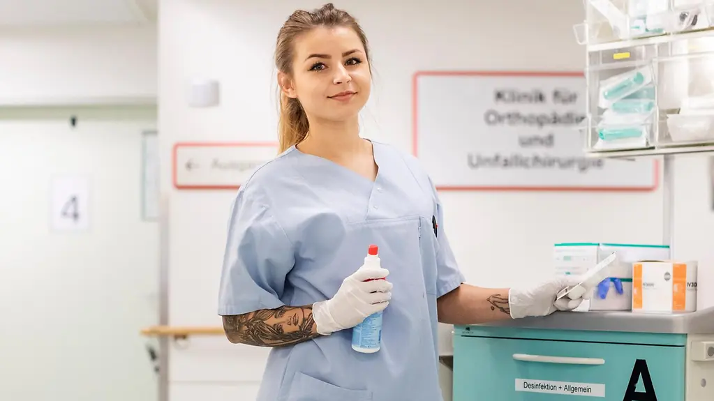 Eine junge Frau aus der Pflegebranche steht in einer Gesundheitseinrichtung