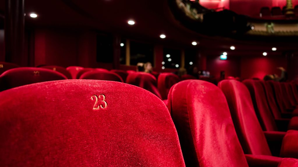 Das Bild zeigt einen riten Sessel in einem Theater.