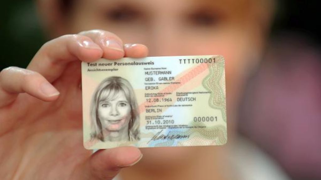 Eine Frau zeigt ihren Personalausweis.