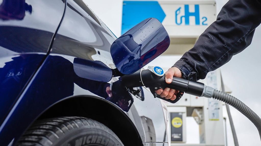 The photo shows a car being filled up with hydrogen at a filling station.