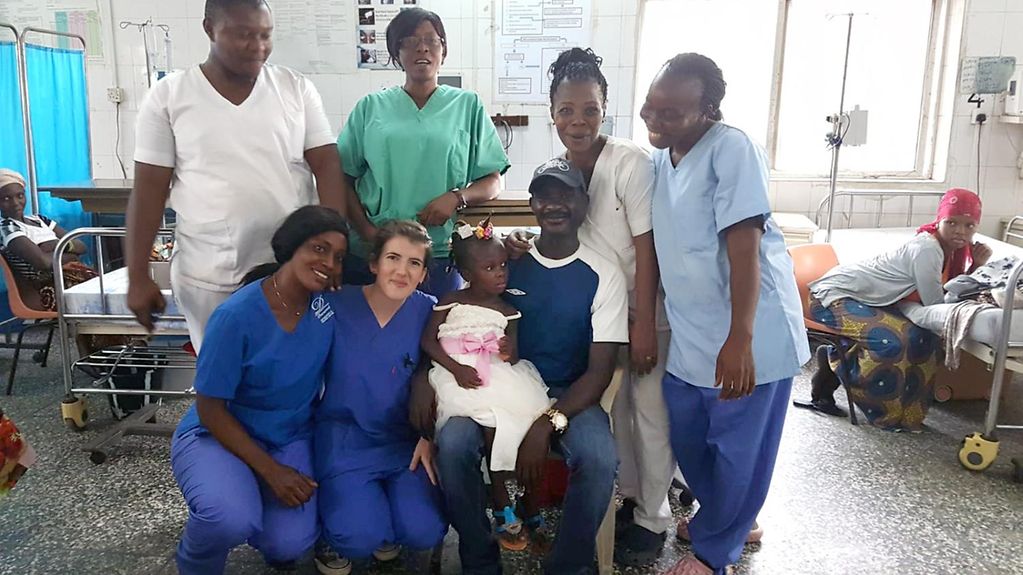 Das Bild zeigt Sarah Hupperich gemeinsam mit Kolleginnen und Kollegen sowie einem Patienten im Krankenhaus in Sierra Leone.