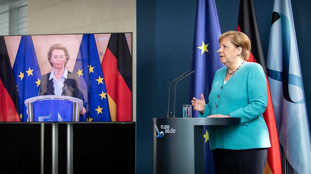 La chancelière fédérale donne une conférence de presse et un écran permet de voir la présidente de la Commission européenne Ursula von der Leyen