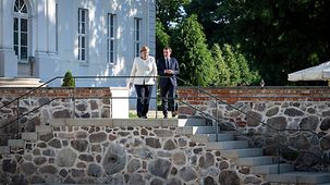 Kanzlerin Merkel und Präsident Macron unternehmen einen Spaziergang im Garten von Schloss Meseberg.
