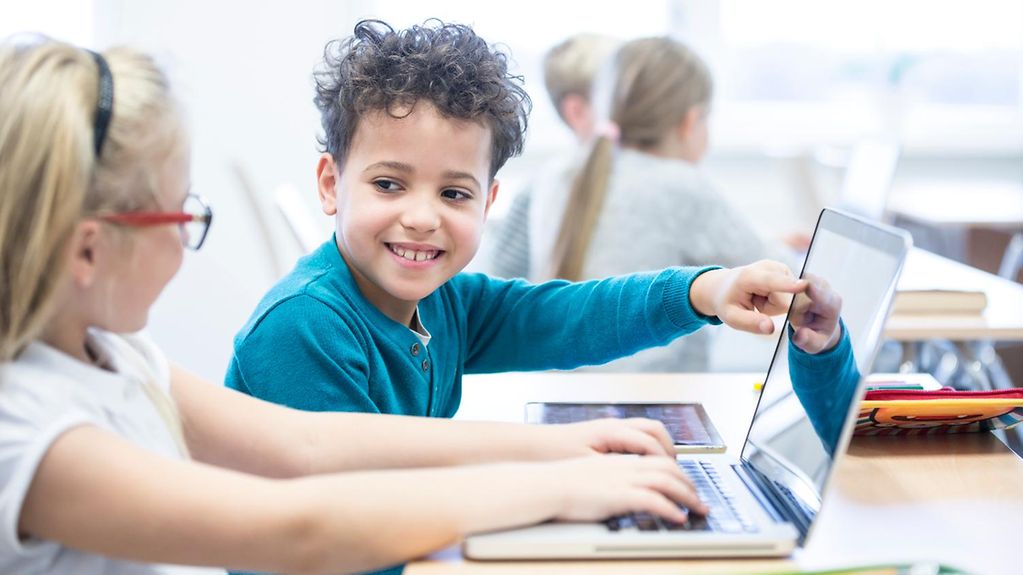 Mittel aus dem Digitalpakt Schule: Zwei Schulkinder nutzen einen Laptop im Unterricht.