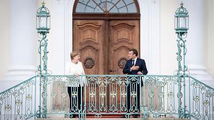 Chancellor Angela Merkel and the French President stand on the steps outside Schloss Meseberg. 