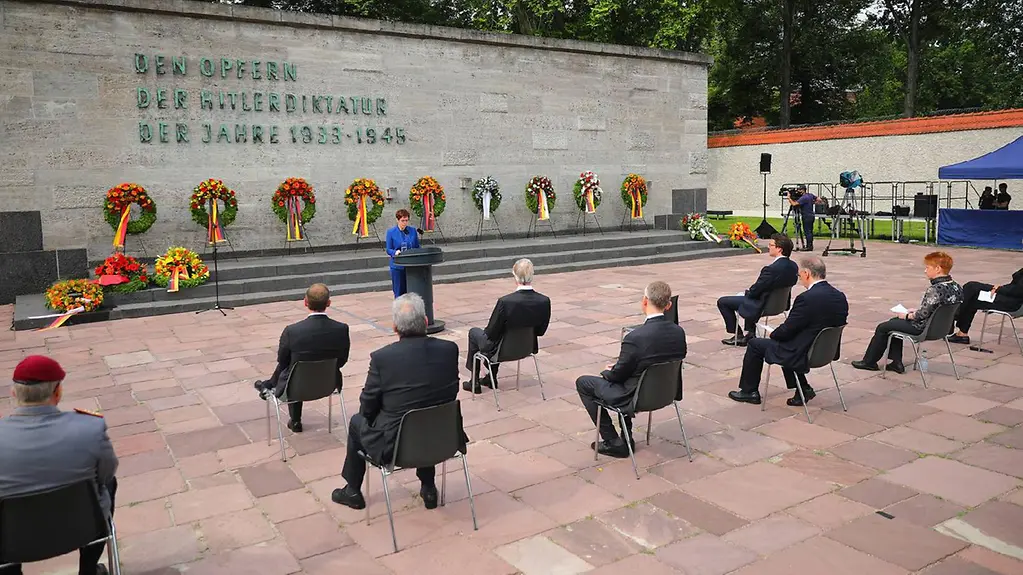 Commémoration du 20 juillet 1944 : la ministre fédérale de la Défense Annegret Kramp-Karrenbauer tient un discours. Derrière elle, l'on peut voir quatre gerbes.