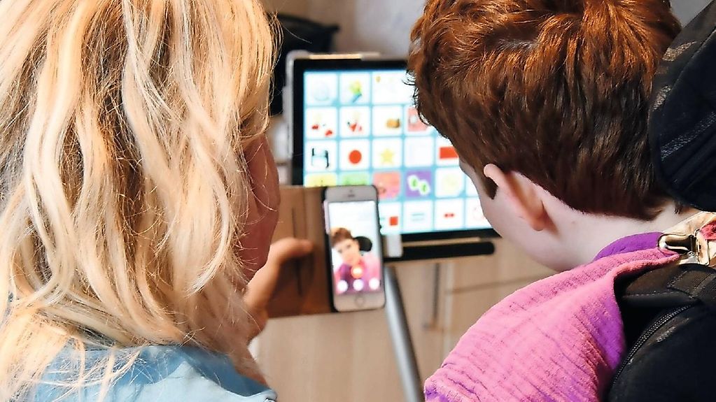 Zwei Kinder schauen in einem Kinderhospiz auf einen Bildschirm mit digitalen Angeboten.
