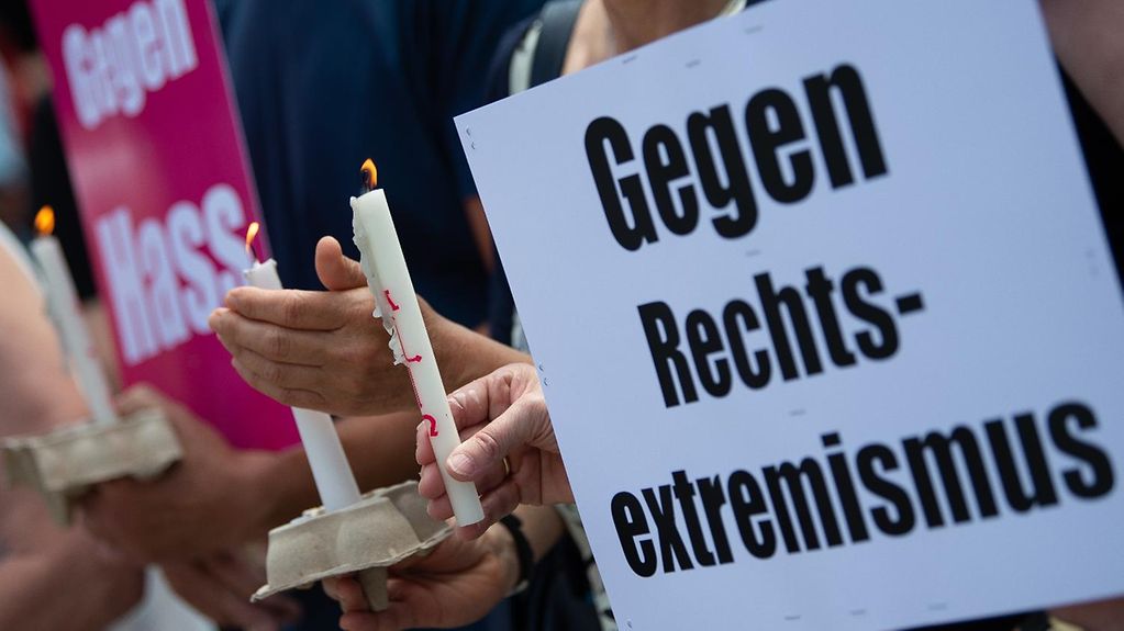 Teilnehmer einer Mahnwache anlässlich des Mordes am Kasseler Regierungspräsidenten Walter Lübcke (CDU) halten Kerzen und Plakate mit der Aufschrift "Gegen Rechtsextremismus" in den Händen. 