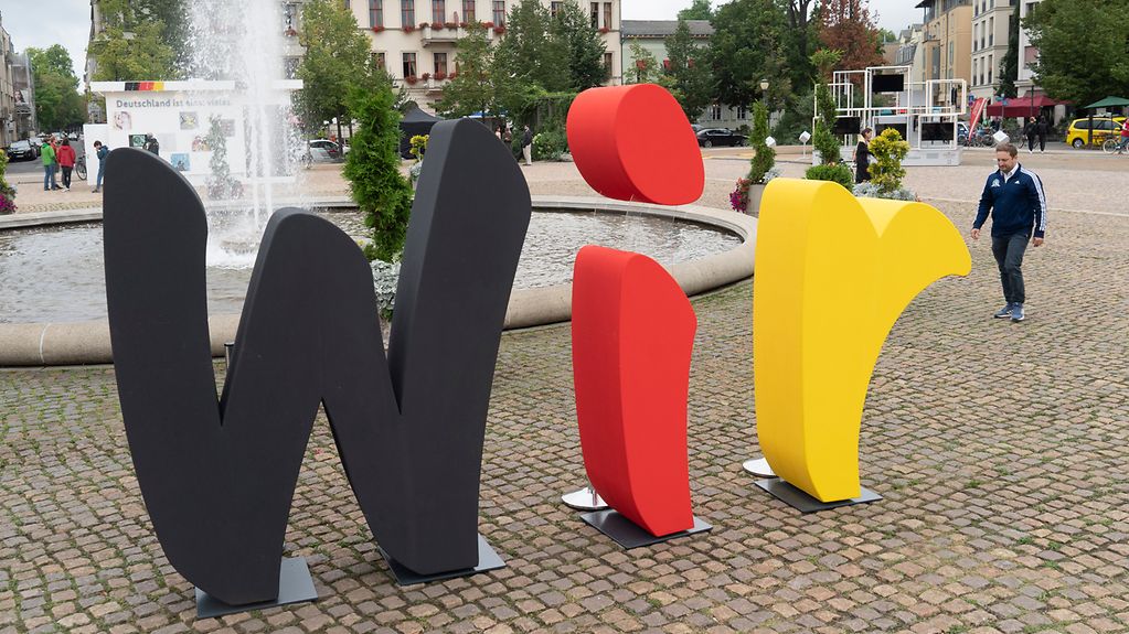 Auf dem Luisenplatz im Potsdam steht in lebensgroßen Buchstabend das Motto der Einheits-Expo "Wir"