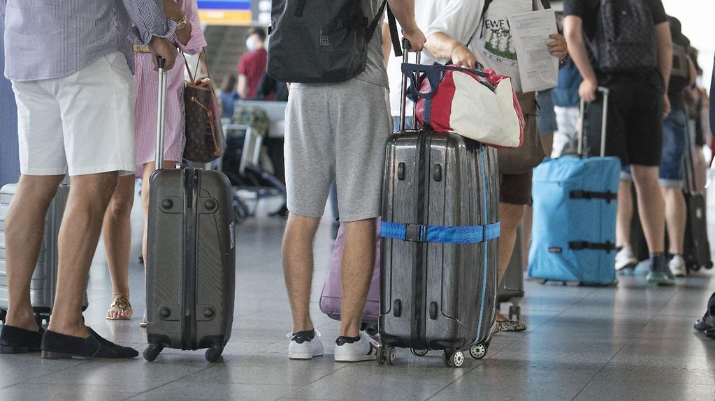 Dans le terminal d’un aéroport, des passagers attendent l‘enregistrement de leurs bagages 