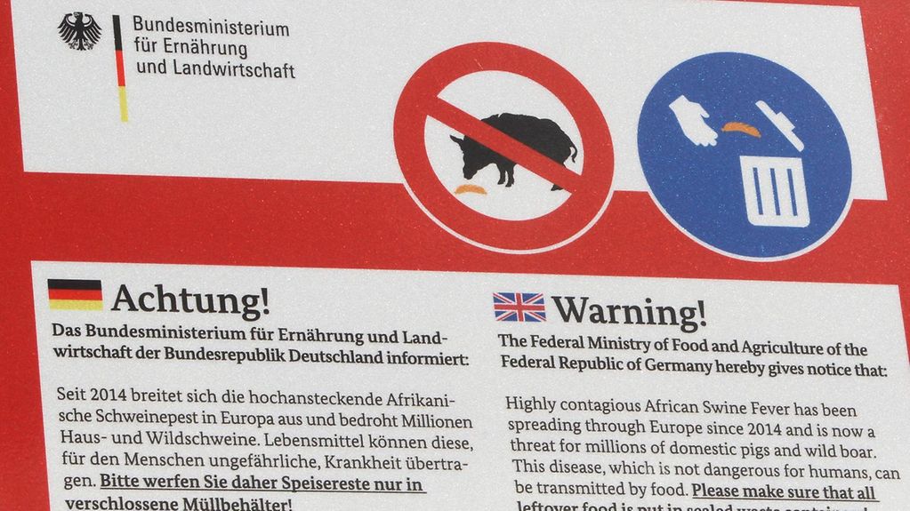 Ein Schild, das auf die Übertragung der Afrikanischen Schweinpest hinweist.