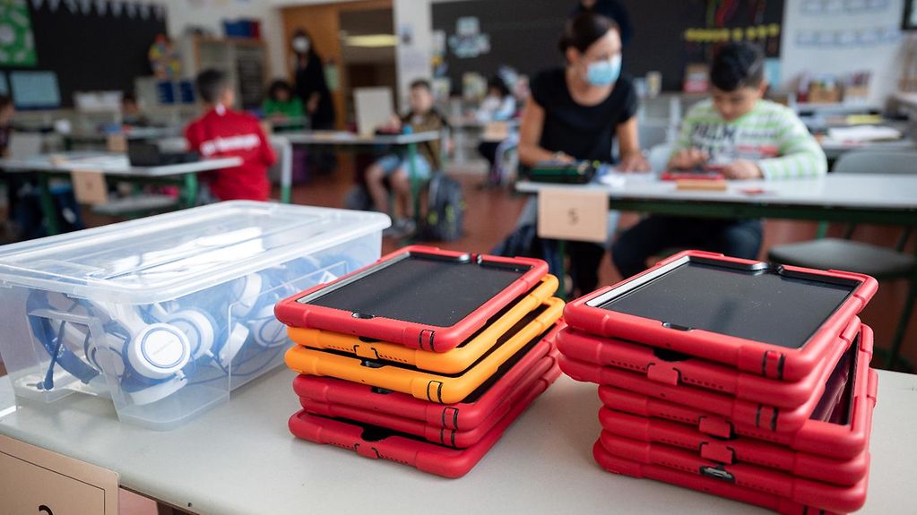 Tablets piled on a desk in a primary school classroom
