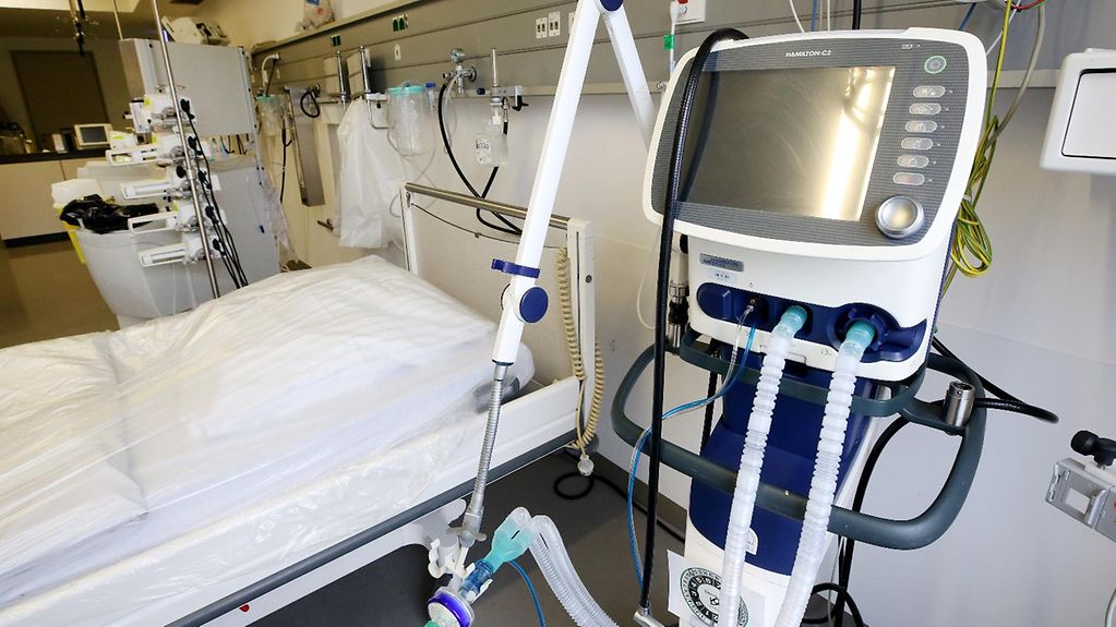 Ein Beatmungsgerät steht neben einem Intensivbett eines Krankenhauses.