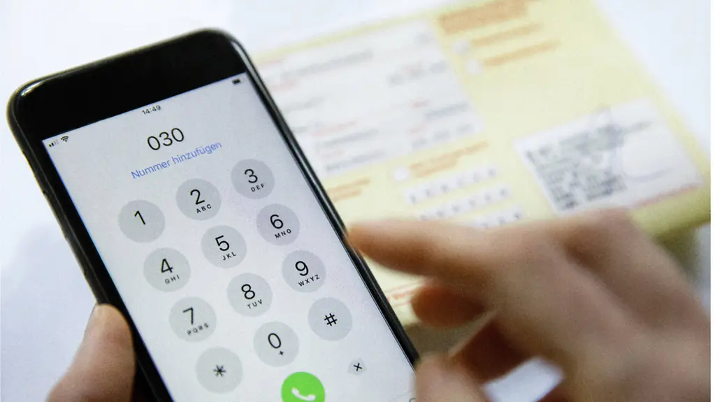 Ein Mobiltelefon und ein Krankenschein