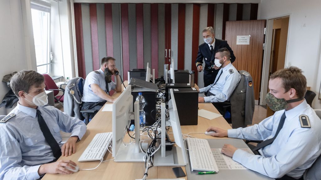 Soldaten der Bundeswehr sitzen an Computern und telefonieren im Gesundheitsamt Hamburg-Eimsbüttel.