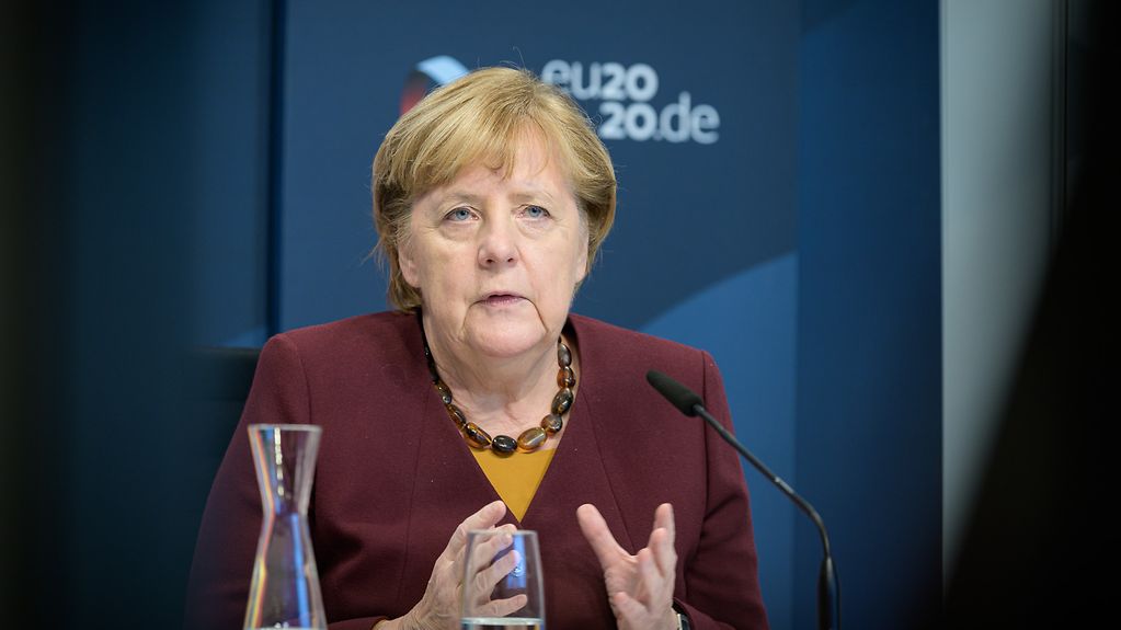 Das Bild zeigt Kanzlerin Merkel, die an einem Tisch im Kanzleramt sitzt.