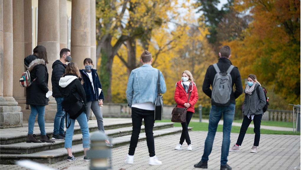 Studierende im ersten Semester stehen während einer Campusführung vor dem Schloss Hohenheim, das zur Uni Hohenheim gehört.