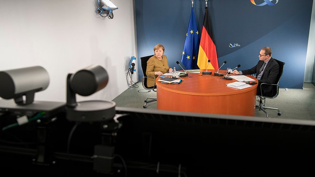 Kanzlerin Merkel und Berlins Regierender Bürgermeister Müller während der Videoschalte im Kanzleramt.