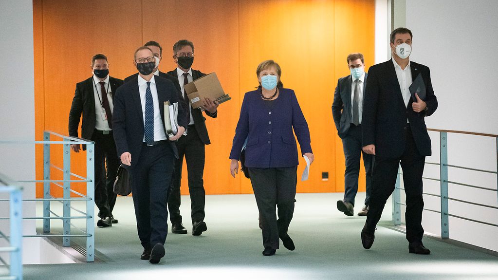 La chancelière fédérale Angela Merkel se rend à la conférence de presse, entourée de Michael Müller, maire et chef du gouvernement du Land de Berlin, et de Markus Söder, ministre-président du Land de Bavière.