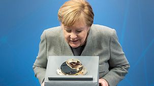 Bundeskanzlerin Angela Merkel schaut sich während des Digitalgipfels ein Exponat an.
