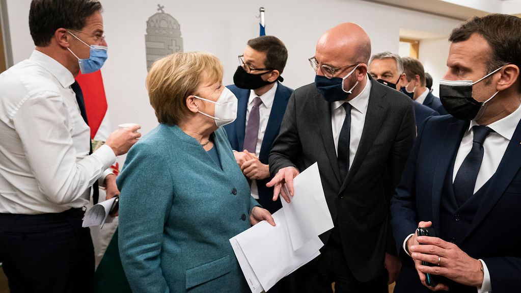 The photo shows Angela Merkel, Charles Michel and Emmanuel Macron.