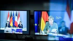 Zwei Monitore im Technikraum des Lagezentrums mit der Angela Merkel, Ursula von der Leyen, Charles Michel, Mark Rutte, Sebastian Kurz, und Emmanuel Macron während einer Videokonferenz.