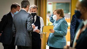 Angela Merkel and her advisors in discussion with French President Emmanuel Macron on the sidelines of a European Council meeting 