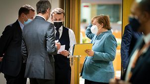 Angela Merkel et des conseillers de la chancelière en conversation avec Emmanuel Macron, le président français, en marge d’une réunion du Conseil européen dans le bâtiment Europa