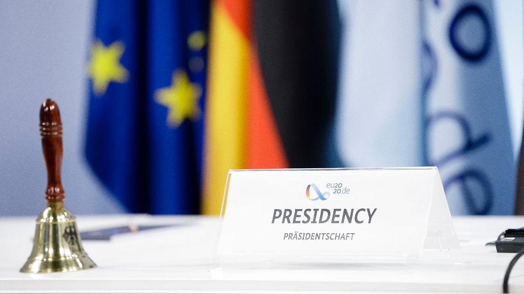 Le drapeau de la présidence allemande du Conseil de l’UE arborant son logo, aux côtés des drapeaux de l’UE et de l’Allemagne 