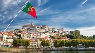 The old university town of Coimbra, with a Portuguese flag in the foreground