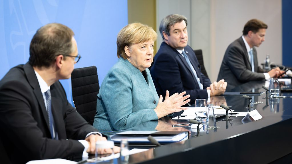 Bundeskanzlerin Angela Merkel spricht während einer Pressekonferenz zwischen Michael Müller, Berlins Regierender Bürgermeister, und Markus Söder, bayerischer Ministerpräsident.
