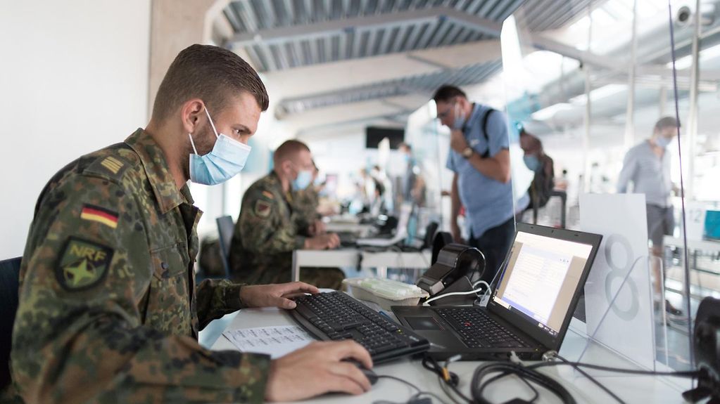 Soldaten der Bundeswehr unterstützen bei der Registrierung ankommender Reisender an einem Flughafen bei Corona-Tests im Rahmen der Amtshilfe während der Corona-Pandemie.