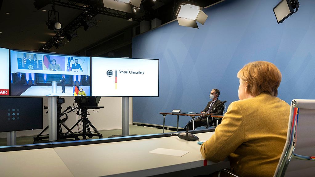 At the Federal Chancellery, Chancellor Angela Merkel sets at a desk and takes part in the online Munich Security Conference.