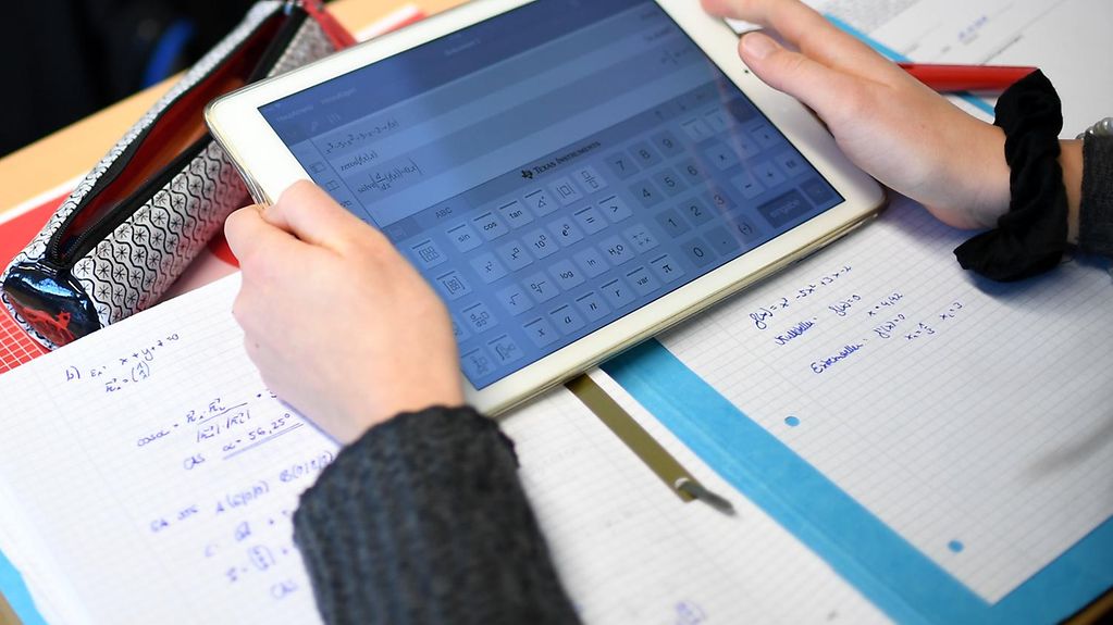 Ein Schüler errechnet eine Mathe-Gleichung mit einem Tablet.