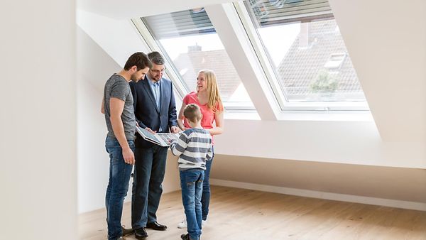 Ein Makler präsentiert einer Familie eine Wohnung
