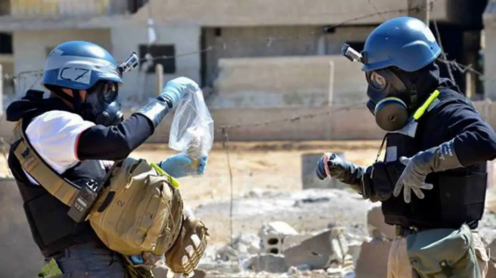 UN-Inspektoren in Schutzkleidung nehmen Bodenproben in Syrien