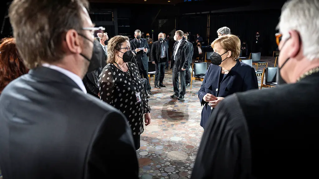 Chancellor Angela Merkel meets the mother of a victim at the service in Berlin's Memorial Church for those who have lost their lives in the pandemic.