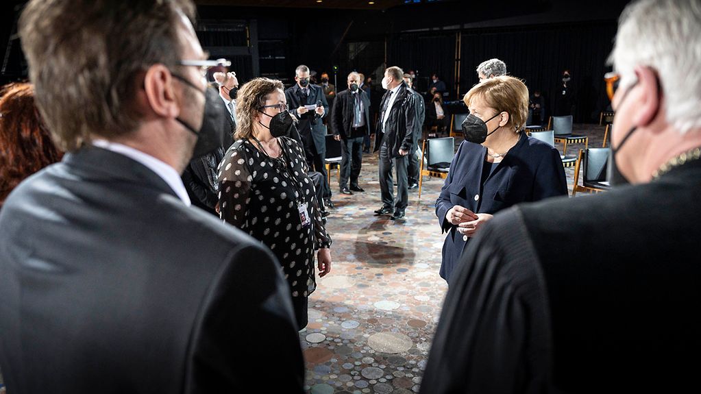Chancellor Angela Merkel meets the mother of a victim at the service in Berlin's Memorial Church for those who have lost their lives in the pandemic.