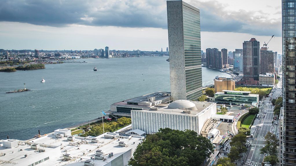 The photo shows the exterior of the United Nations Headquarters.